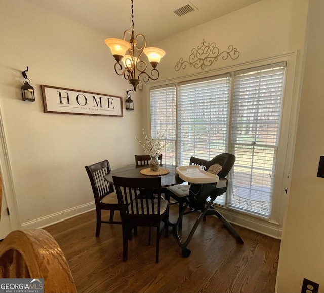 dining space with dark hardwood / wood-style flooring, vaulted ceiling, and a notable chandelier