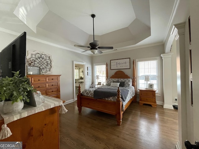 bedroom featuring ornamental molding, dark wood-type flooring, ceiling fan, and a tray ceiling