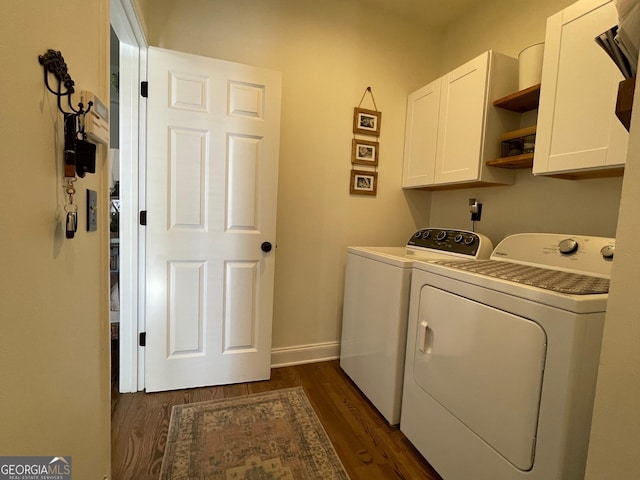 clothes washing area with cabinets, washing machine and dryer, and dark hardwood / wood-style flooring