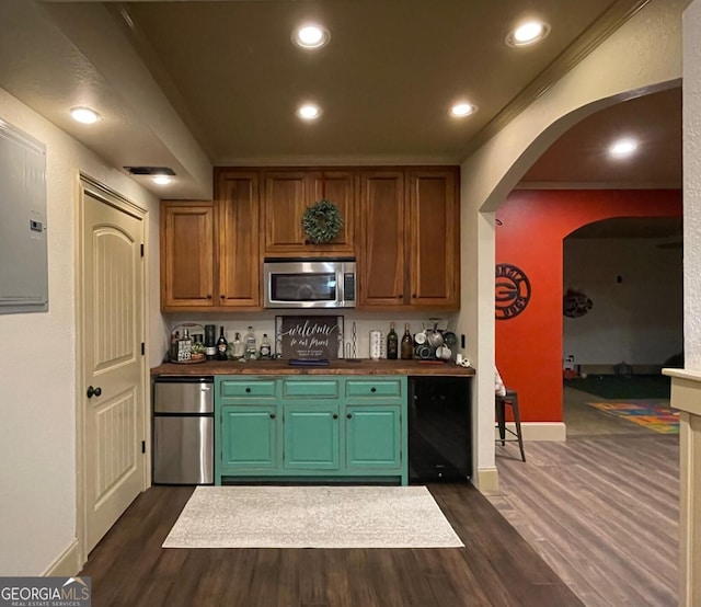 kitchen with appliances with stainless steel finishes and dark hardwood / wood-style floors