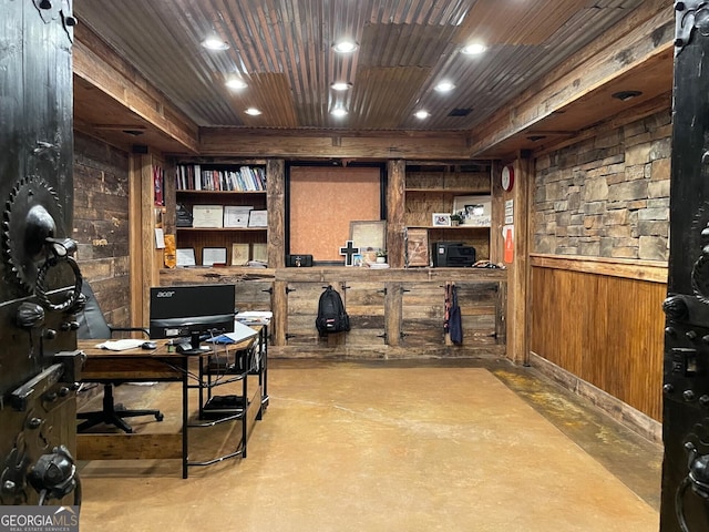 home office with wood ceiling, concrete flooring, and wood walls