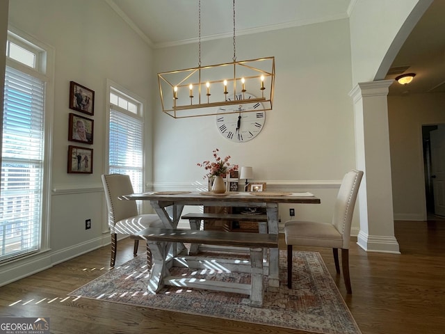 dining space featuring ornate columns, crown molding, and dark wood-type flooring