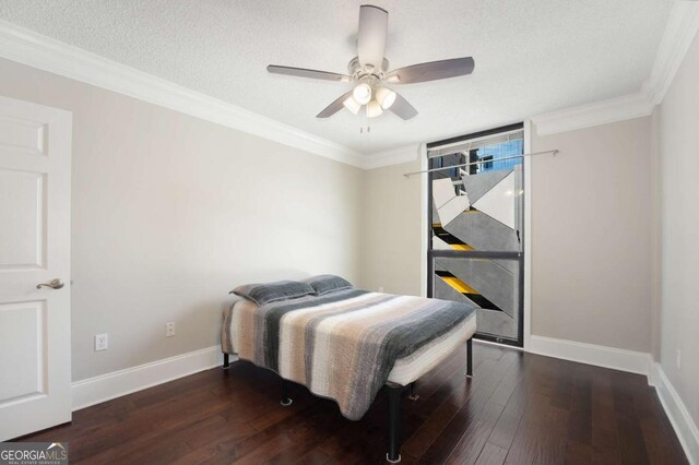 bedroom featuring ceiling fan, crown molding, dark wood-type flooring, and a textured ceiling