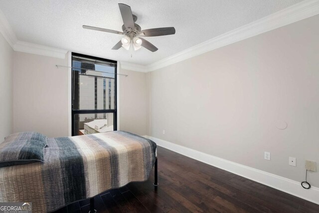 bedroom with ornamental molding, a textured ceiling, ceiling fan, and dark wood-type flooring