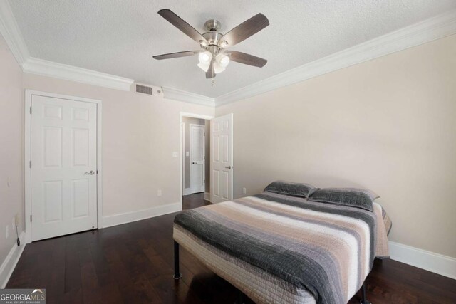 bedroom with ceiling fan, crown molding, dark wood-type flooring, and a textured ceiling