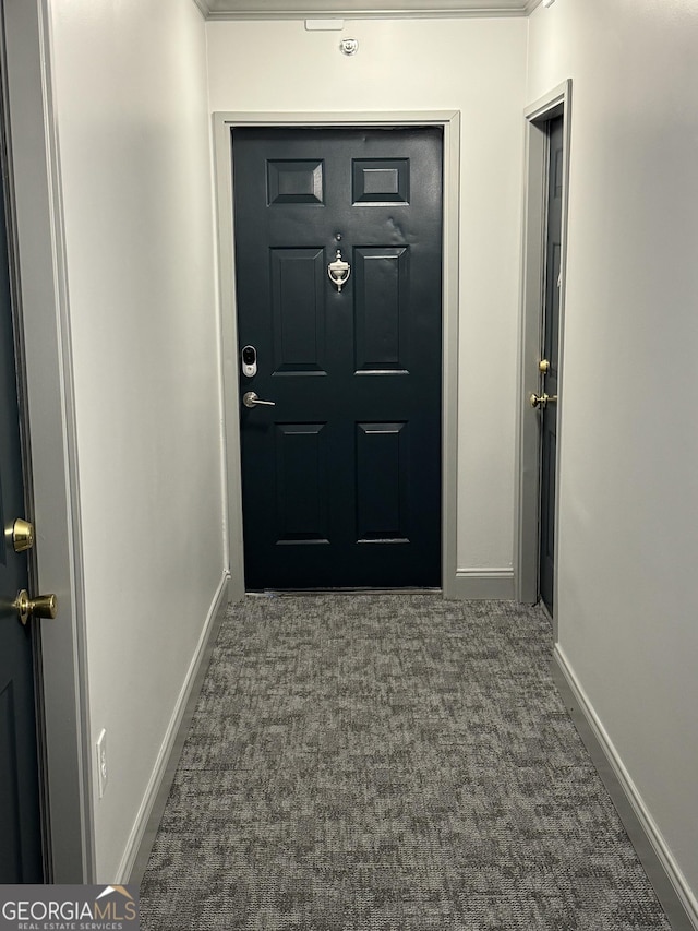 entryway featuring dark carpet and crown molding