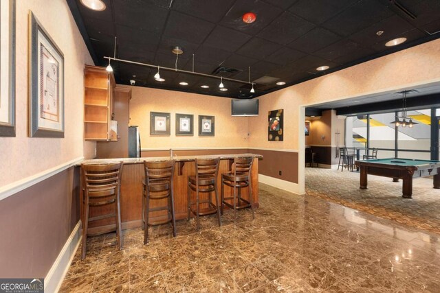 bar featuring stainless steel refrigerator, rail lighting, decorative light fixtures, and billiards