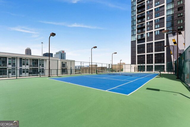 view of tennis court with basketball hoop