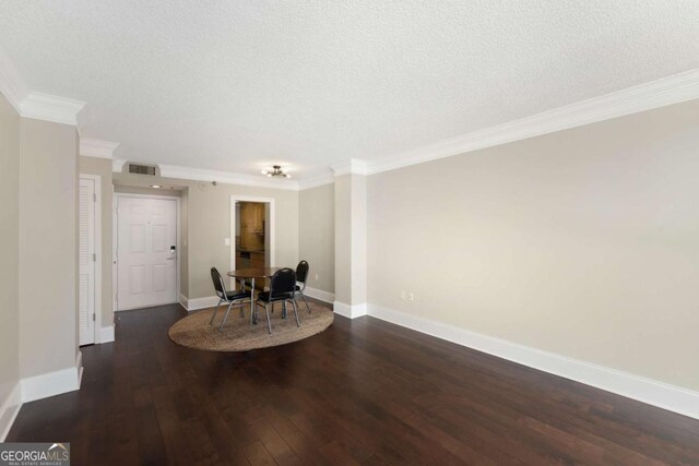 dining room featuring a textured ceiling, dark hardwood / wood-style floors, and crown molding