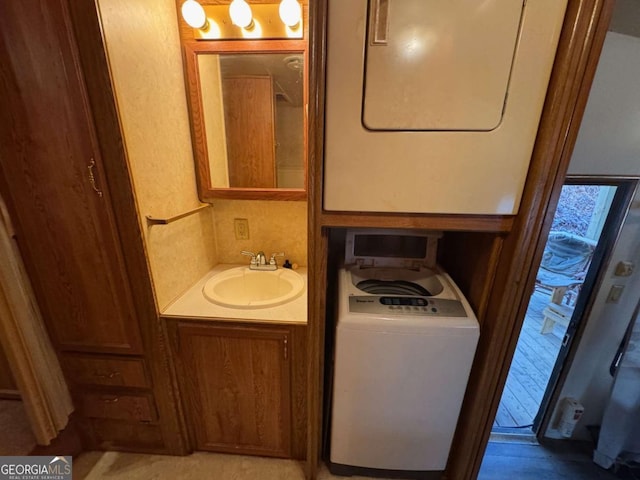 clothes washing area with stacked washer / dryer and sink