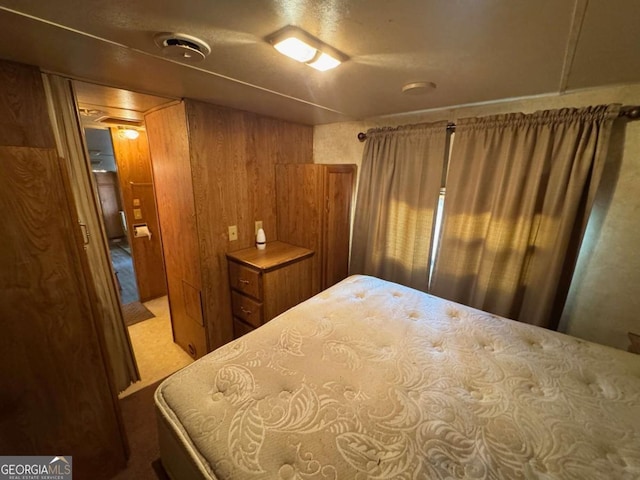 bedroom with carpet and wood walls