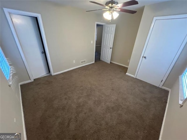 unfurnished bedroom featuring dark carpet and ceiling fan