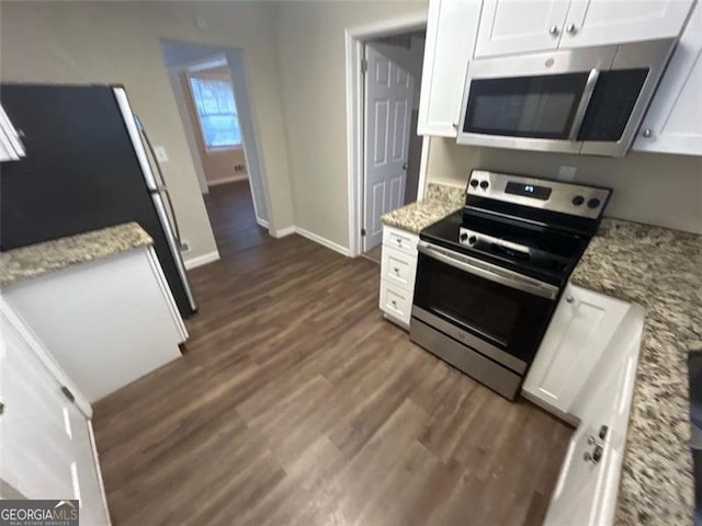 kitchen featuring light stone countertops, white cabinetry, and appliances with stainless steel finishes