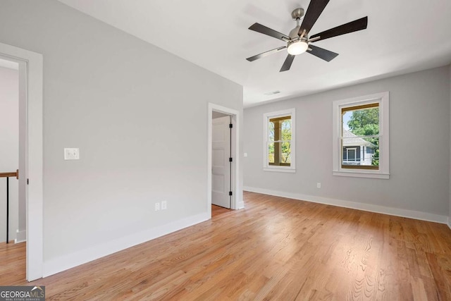 empty room with ceiling fan and light hardwood / wood-style flooring