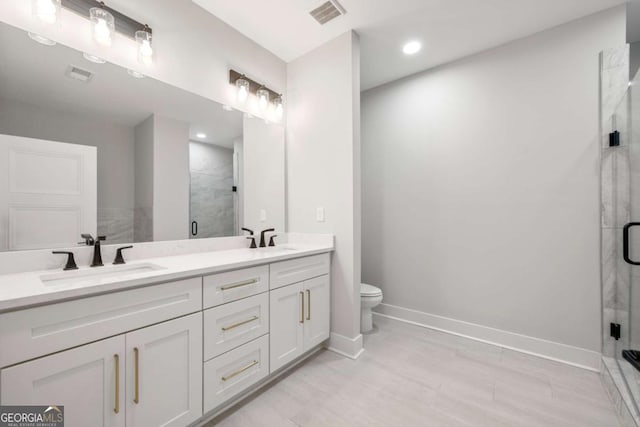 bathroom featuring vanity, toilet, and a shower with door