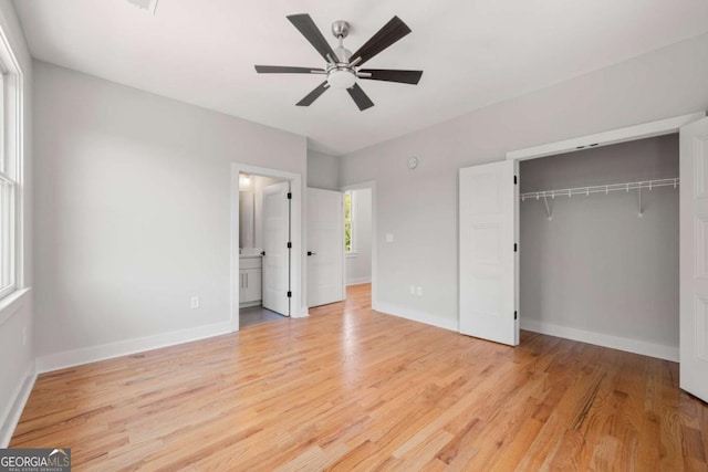 unfurnished bedroom with a closet, light hardwood / wood-style floors, ceiling fan, and connected bathroom