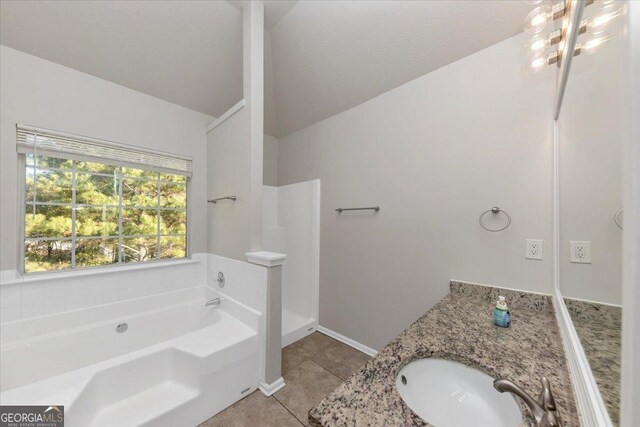 bathroom with a washtub, tile patterned flooring, a textured ceiling, vaulted ceiling, and vanity