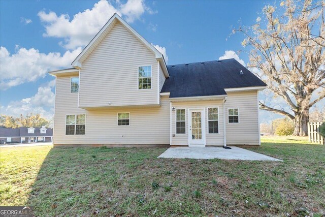 rear view of property featuring a lawn and a patio area