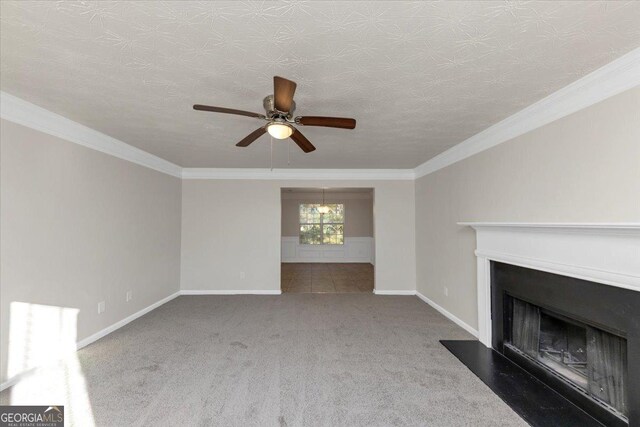 unfurnished living room with a textured ceiling, carpet floors, ceiling fan, and crown molding