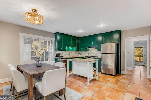 kitchen with sink, decorative backsplash, stainless steel appliances, and green cabinetry