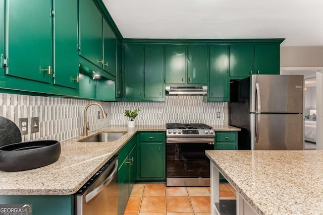 kitchen featuring light stone counters, sink, stainless steel appliances, and green cabinets