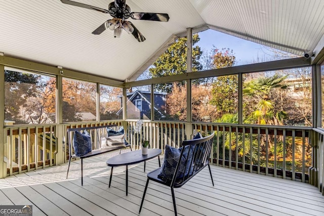 unfurnished sunroom with ceiling fan, plenty of natural light, and vaulted ceiling