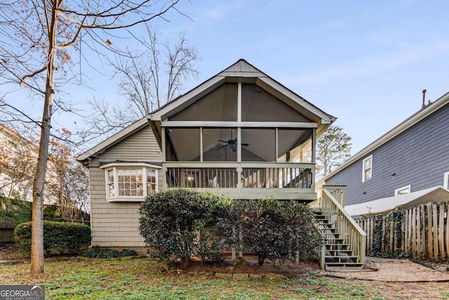 rear view of property featuring ceiling fan and a sunroom