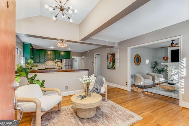 interior space with hardwood / wood-style flooring, lofted ceiling, and ceiling fan with notable chandelier