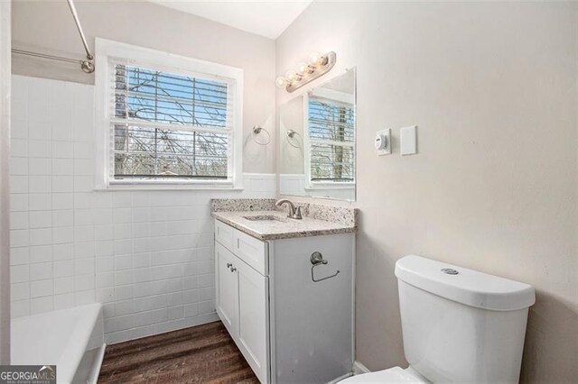 bathroom with hardwood / wood-style floors, vanity, and toilet