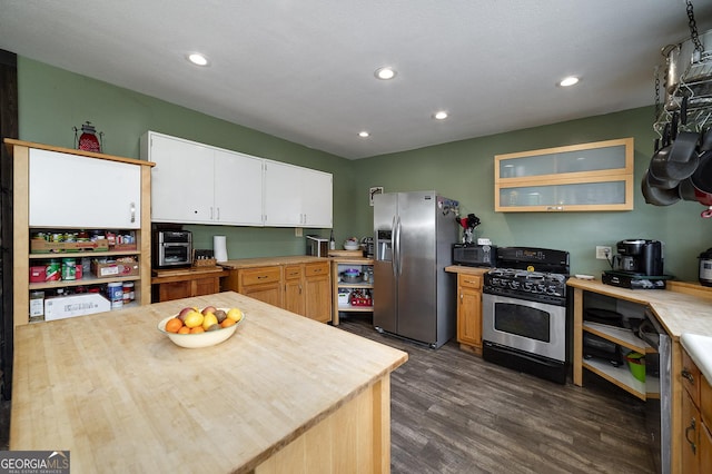 kitchen with white cabinets, dark wood-type flooring, appliances with stainless steel finishes, and a textured ceiling