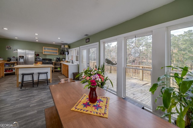 dining space with plenty of natural light, wood-type flooring, french doors, and sink