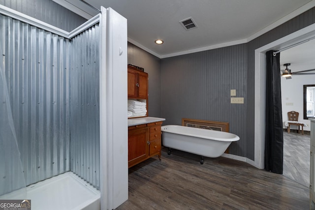 bathroom with crown molding, ceiling fan, decorative backsplash, a tub to relax in, and wood-type flooring