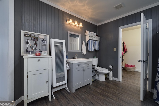 bathroom with crown molding, hardwood / wood-style floors, vanity, and toilet