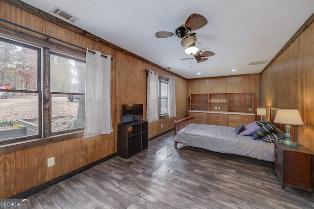 bedroom with dark hardwood / wood-style floors, wooden walls, and multiple windows