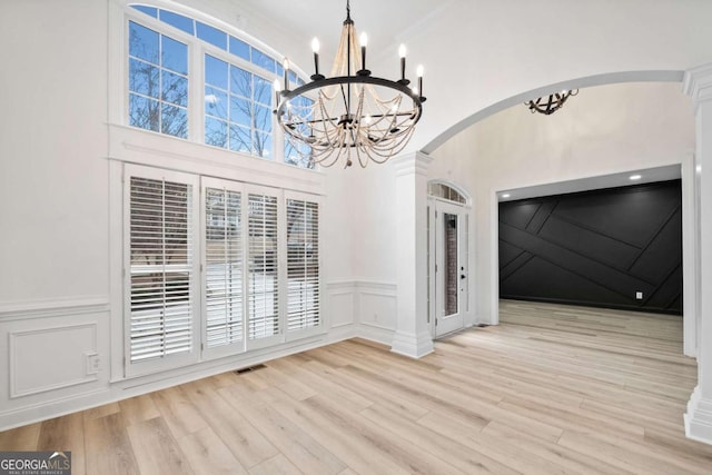 unfurnished dining area featuring a notable chandelier and light wood-type flooring