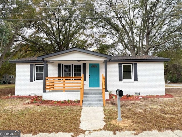 view of front of house featuring covered porch and a front yard