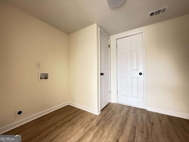 clothes washing area featuring hardwood / wood-style flooring, hookup for an electric dryer, and hookup for a washing machine