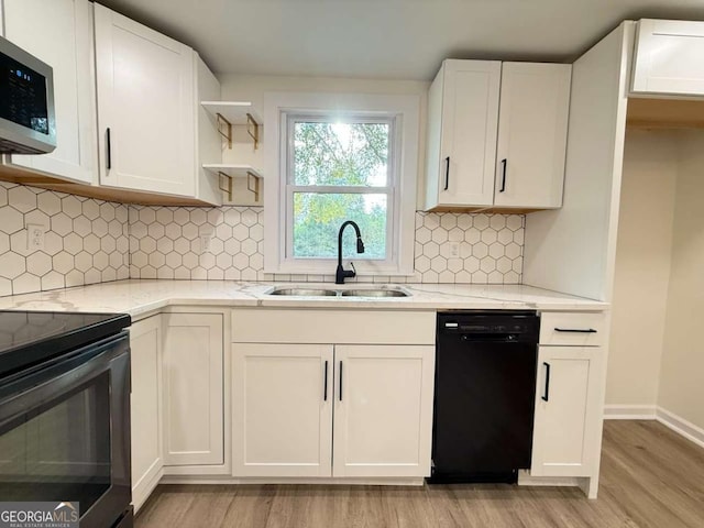 kitchen featuring light wood-type flooring, sink, light stone counters, and black appliances