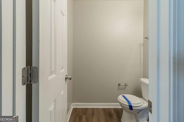 bathroom featuring hardwood / wood-style flooring and toilet