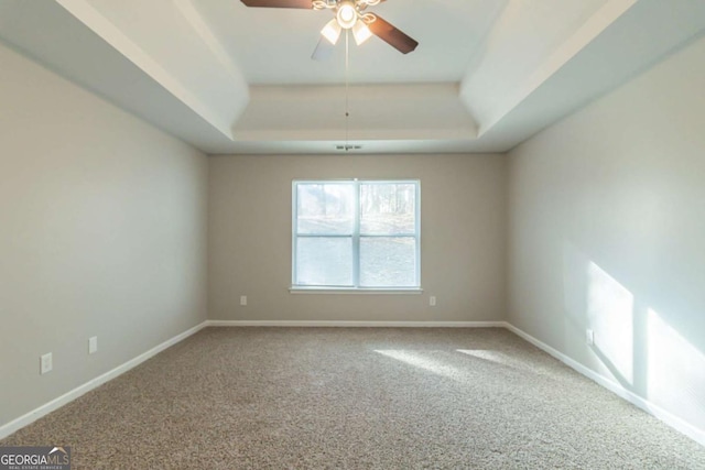 unfurnished room with carpet floors, a raised ceiling, and ceiling fan