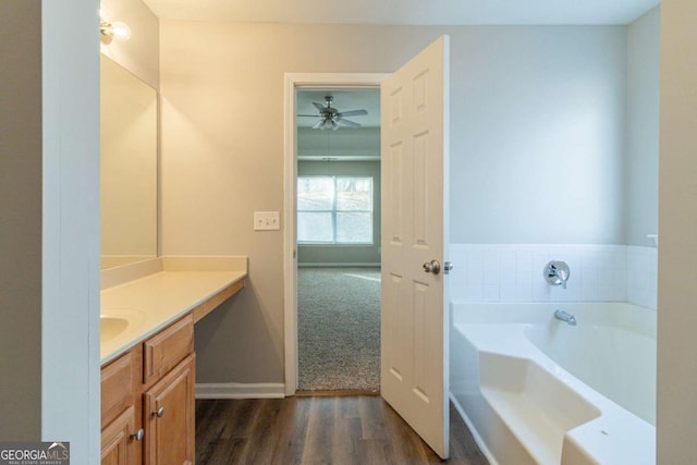 bathroom featuring ceiling fan, vanity, a bath, and hardwood / wood-style flooring