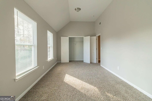 unfurnished bedroom featuring a closet, lofted ceiling, carpet floors, and multiple windows