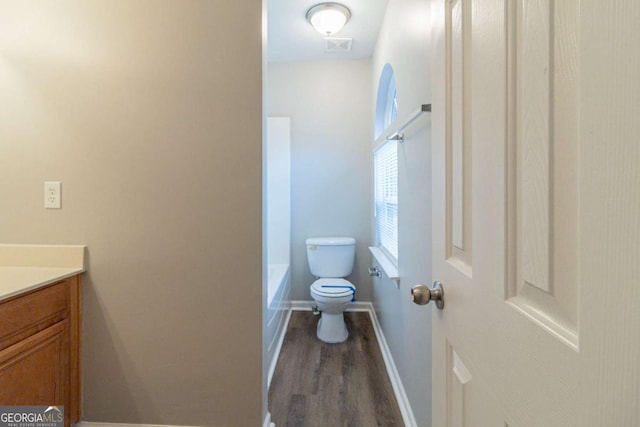 bathroom with vanity, toilet, and wood-type flooring