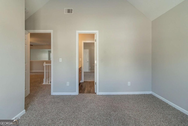 unfurnished bedroom with carpet flooring and high vaulted ceiling