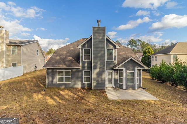 back of property with a lawn and a patio