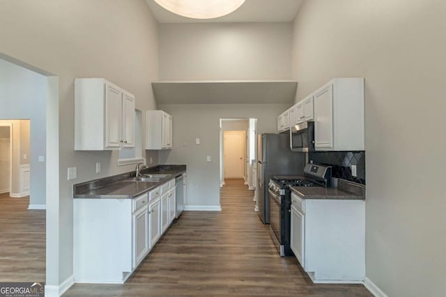 kitchen featuring white cabinets, sink, stainless steel appliances, and dark wood-type flooring