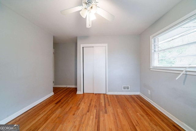 unfurnished bedroom featuring a closet, light hardwood / wood-style floors, and ceiling fan