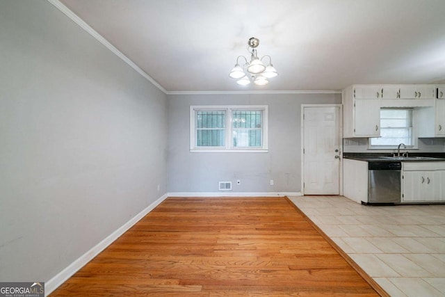 kitchen with white cabinetry, dishwasher, plenty of natural light, and an inviting chandelier