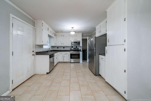 kitchen featuring white cabinets, sink, light tile patterned floors, ornamental molding, and stainless steel appliances