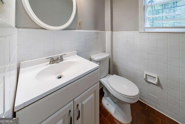 bathroom featuring vanity, toilet, and tile walls